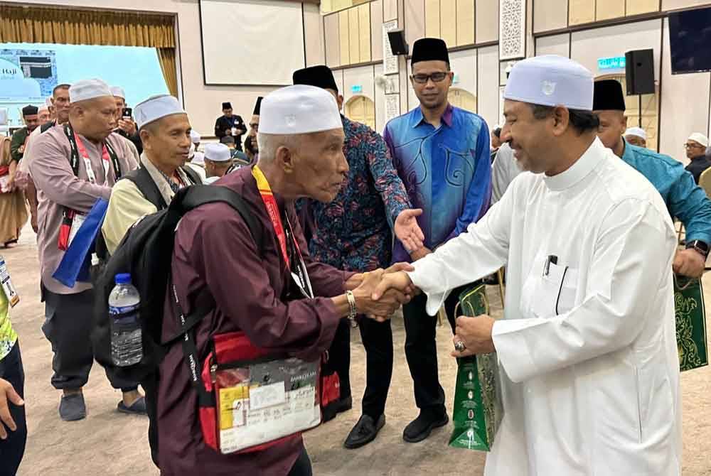 Mohd Nassuruddin (kanan) bersalaman dan mengucapkan selamat jalan kepada jemaah haji.