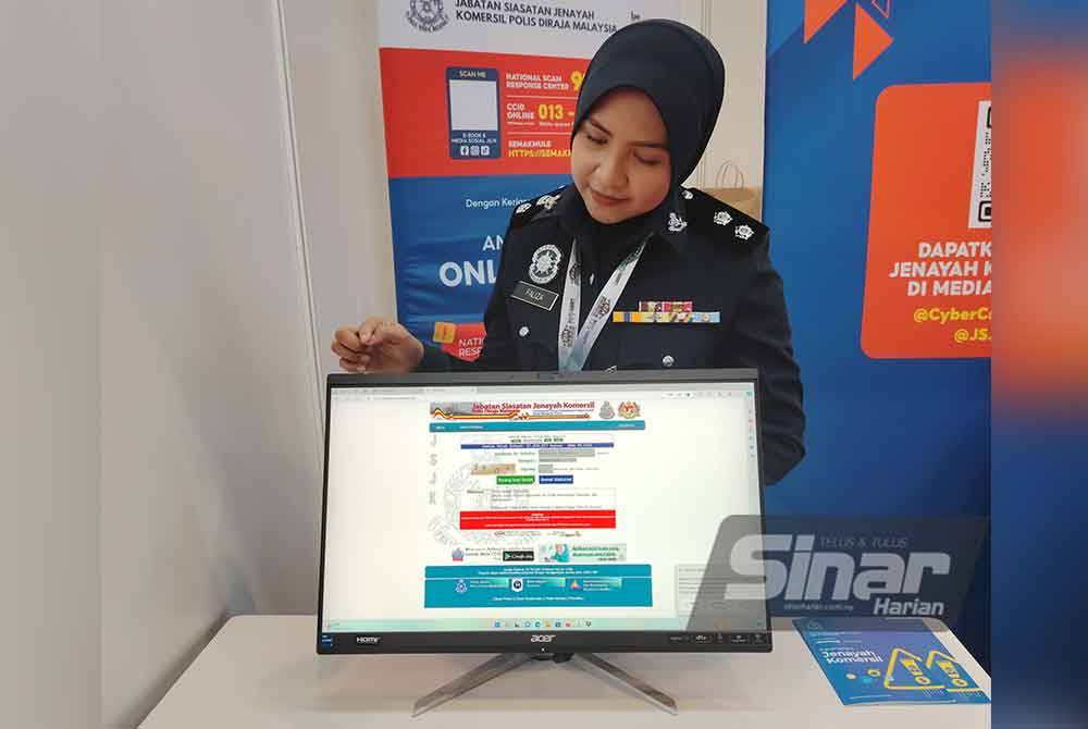 NorFaliza menunjukkan portal Semakmula yang menjadi antara perhatian pengunjung di reruai JSJK pada DSA dan NATSEC Asia 2024 di MITEC Kuala Lumpur.