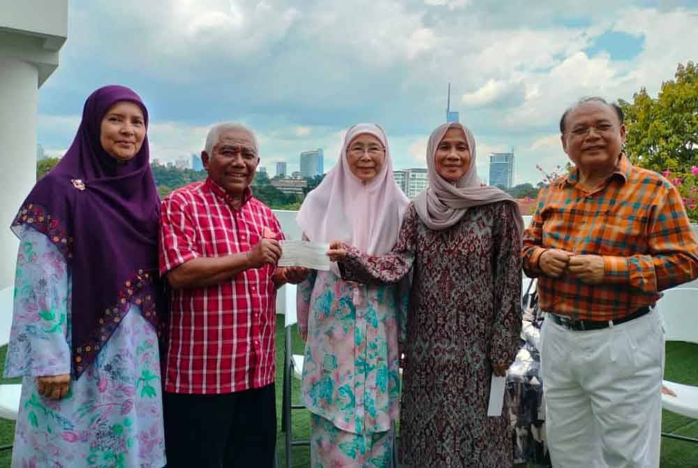 Muhamad Fasri (kanan) dan isteri, Rusnah (dua dari kanan) menyerahkan zakat bernilai RM1 juta kepada Abdul Razak (dua dari kiri) untuk kerja-kerja dakwah di Pulau Cebu, Filipina.