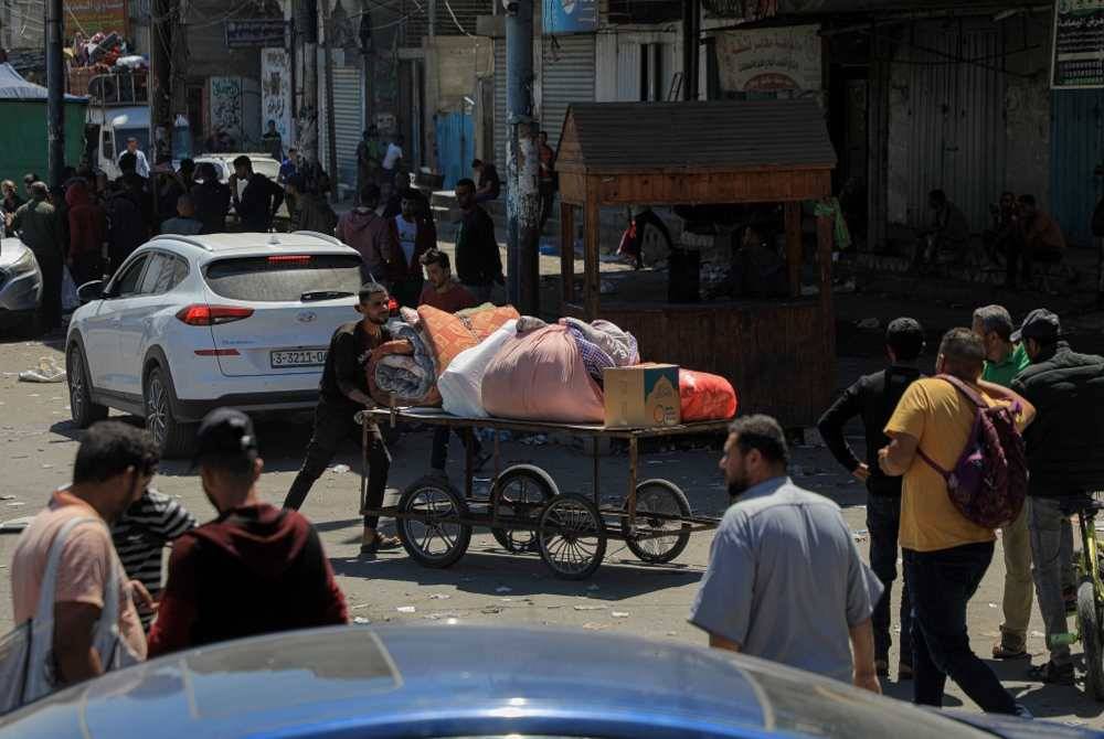 Orang ramai meninggalkan rumah mereka di bandar Rafah di selatan Semenanjung Gaza selepas tentera Israel mengumumkan mereka akan meneruskan serangan darat ke atas Rafah di Gaza pada Rabu. Foto Xinhua