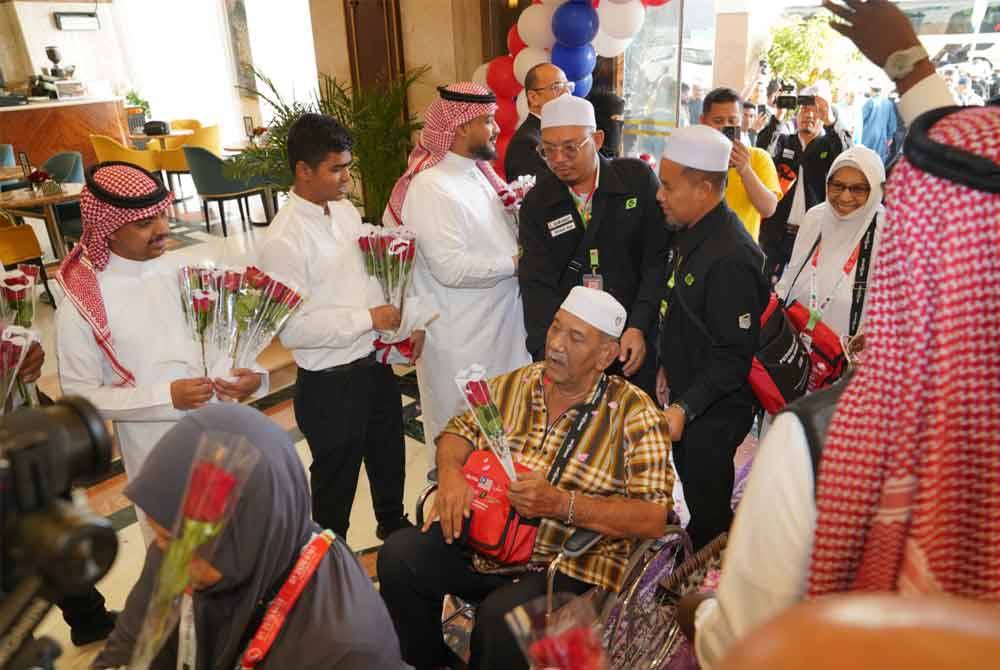 Abdul Ghani Ismail (kerusi roda) dibantu petugas TH memasuki lobi Hotel Emaar Royal ketika majlis sambutan ketibaan jemaah haji KT1.