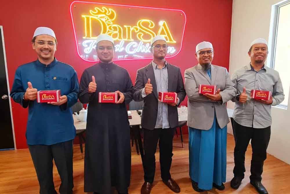 Mohammad Faiz (tengah) bersama pengurusan tertinggi DaRsa Fried Chicken (DFC) di Rawang pada Jumaat.