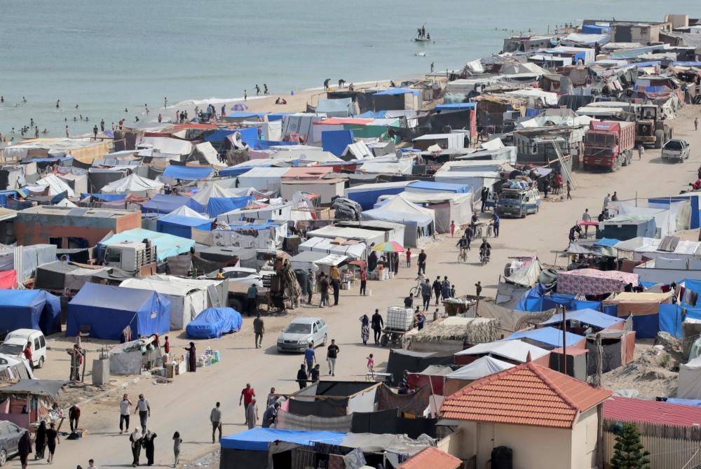 Penduduk Palestin meletakkan barang-barang mereka di atas kenderaan di tengah-tengah khemah di sepanjang pantai di Deir el-Balah di tengah Semenanjung Gaza pada Jumaat. Foto AFP