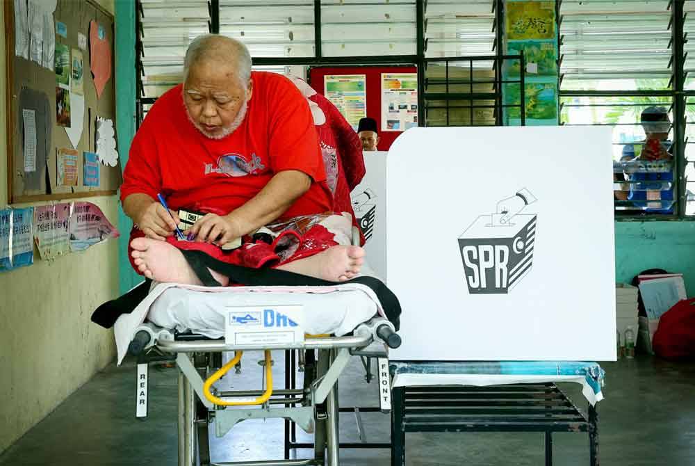 Bekas pemandu ambulan Zul Majid diusung di atas katil dari rumahnya untuk mengundi di Pusat Mengundi SMK Ampang Pecah, Kuala Kubu Baharu sempena PRK Kuala Kubu Baharu hari ini. - Foto: Bernama