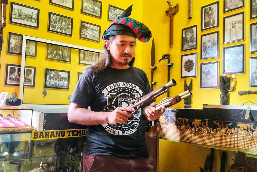 Mohamad Muzammir bersama replika pistol klasik Belanda yang dimilikinya