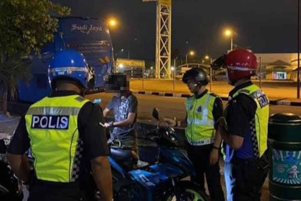 Anggota polis memeriksa motosikal yang ditahan untuk tujuan pemeriksaan.