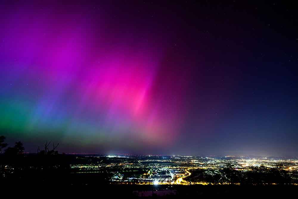 Cahaya utara atau aurora borealis muncul di kaki langit Vienna ketika ribut geomagnet pada Sabtu. - Foto AFP