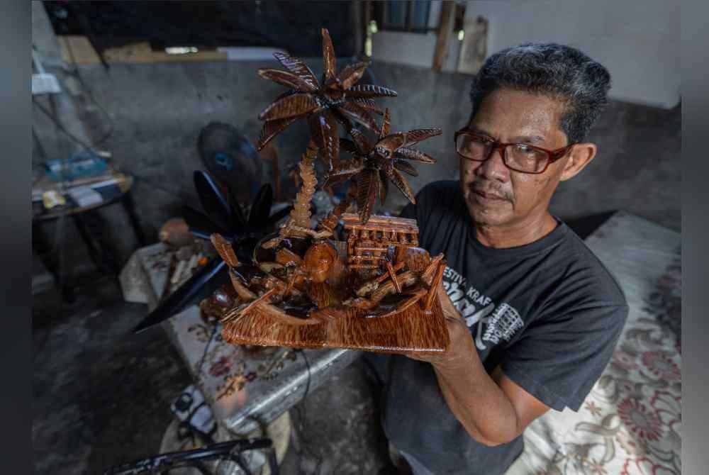 
Mad Saril menunjukkan kraf tangan dari tempurung dan batang kelapa yang dihasilkannya. Foto Bernama