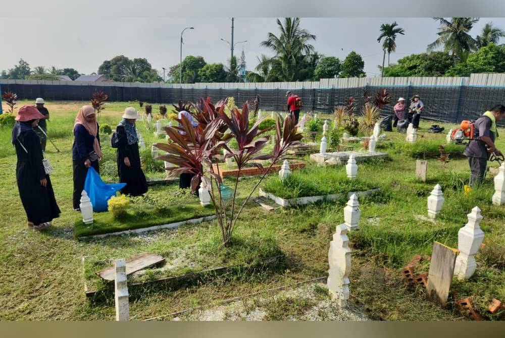 Sebahagian ahli keluarga menziarahi kubur pada Program Gotong-Royong di Tanah Perkuburan Islam Selat Klang pada Isnin.