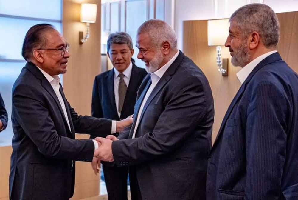 Anwar (kiri) menerima taklimat mengenai situasi di Gaza dan Rafah oleh deligasi Hamas yang diketuai oleh pemimpinnya, Ismail Haniyeh.