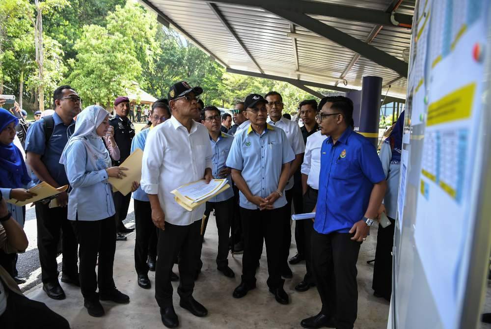 Saifuddin Nasutionbersama Menteri Besar Perlis, Mohd Shukri Ramli mendengar taklimat mengenai projek Kompleks Imigresen, Kastam, Kuarantin dan Keselamatan (ICQS) Wang Kelian ketika mengadakan lawatan kerja di sini pada Selasa. Foto Bernama