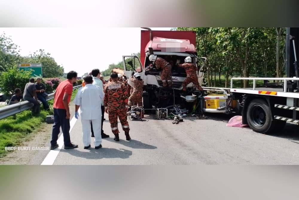 Anggota bomba mengeluarkan pemandu lori yang tersepit di tempat kejadian di Lebuhraya Utara Selatan, Tangkak pada Selasa. Foto BBP Bukit Gambir