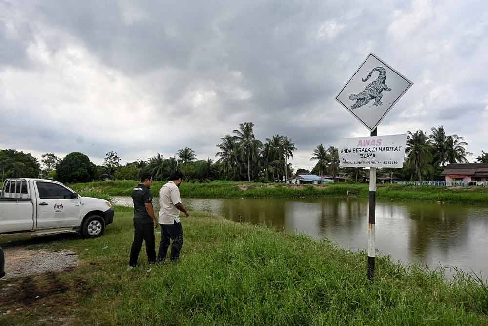 Dua pegawai Perhilitan sedang membuat pemantauan di Sungai Malim pada Rabu.