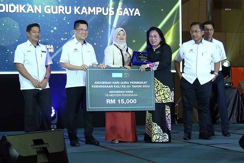 Fadhlina (tiga, kiri) menyampaikan anugerah salah seorang penerima sempena Majlis Anugerah Sempena Sambutan Hari Guru Peringkat Kebangsaan 2024 di Pusat Konvensyen Antarabangsa Sultan Ahmad Shah di sini pada Rabu