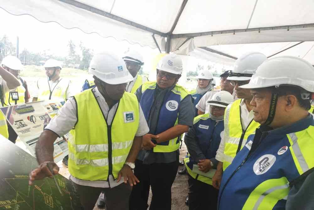 Nanta (kanan) mendengar taklimat daripada pihak LLM semasa meninjau pelaksanaan projek lebuh raya di Seksyen 7 WCE di Persimpangan Assam Jawa-Tanjong Karang, Kuala Selangor pada Khamis.