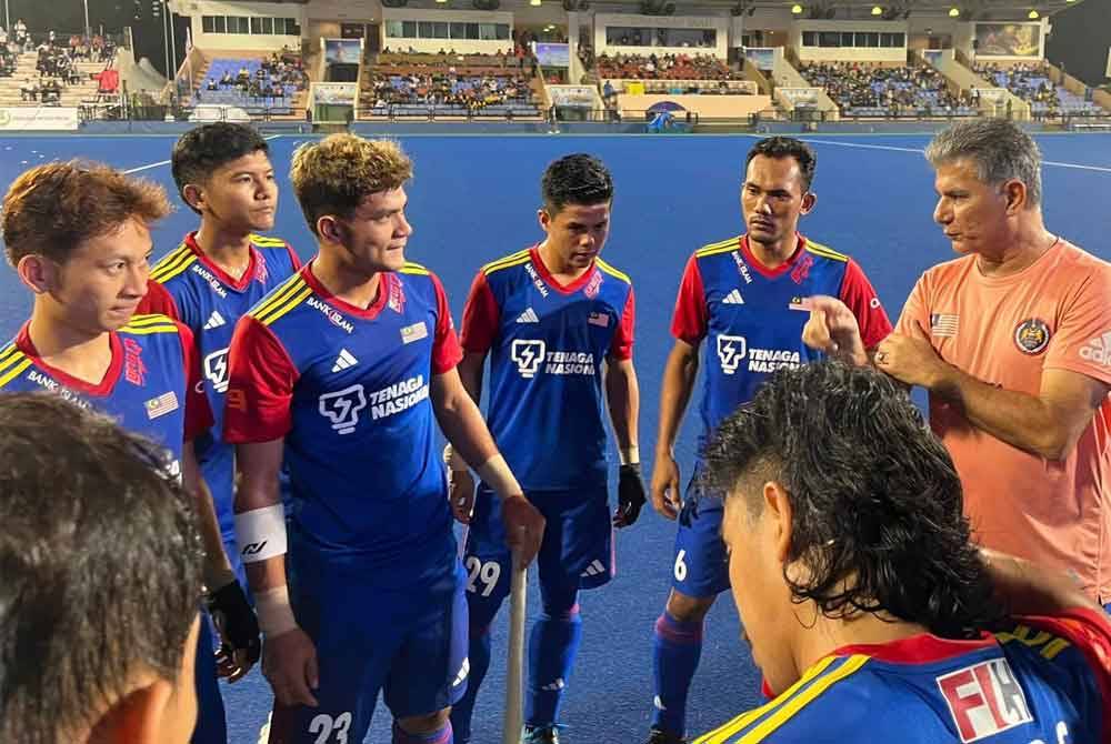 Sarjit Singh (kanan) menyampaikan pesanan kepada pemainnya sebelum aksi menentang Korea Selatan di kejohanan hoki Piala Sultan Azlan Shah di Ipoh baru-baru ini. Foto MHC