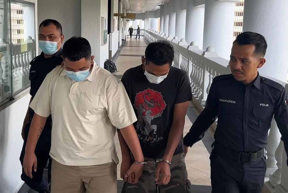 Muhammad Hasan (kiri) dan Muhamad Nur Kholis (dua, kanan) dibawa ke Mahkamah Sesyen Kuala Lumpur pada Jumaat, bagi menghadapi satu pertuduhan bersubahat membaling bom petrol atau ‘molotov cocktails’ ke arah sebuah pusat hiburan di Jalan Yap Kwan Seng minggu lalu.