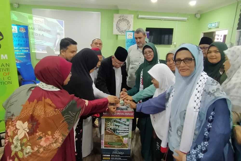 Mohd Azmi (tengah) bersama-sama orang ramai yang memberikan sumbangan sempena Pelancaran Dana Kobar di Kompleks Pendidikan Darul Ridzuan di Ipoh pada Jumaat.