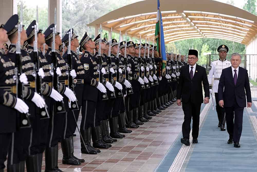 Anwar bersama Mirziyoyev memeriksa perbarisan kawalan kehormat di Istana Presiden Kuksaroy sempena lawatan rasmi beliau ke Uzbekistan bermula hari ini hingga 19 Mei. Foto Bernama