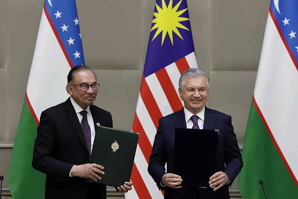 Anwar dan Mirziyoyev bertukar dokumen selepas menandatangani kenyataan bersama pada pertemuan di Istana Presiden Kuksaroy di sini hari ini. Foto Bernama