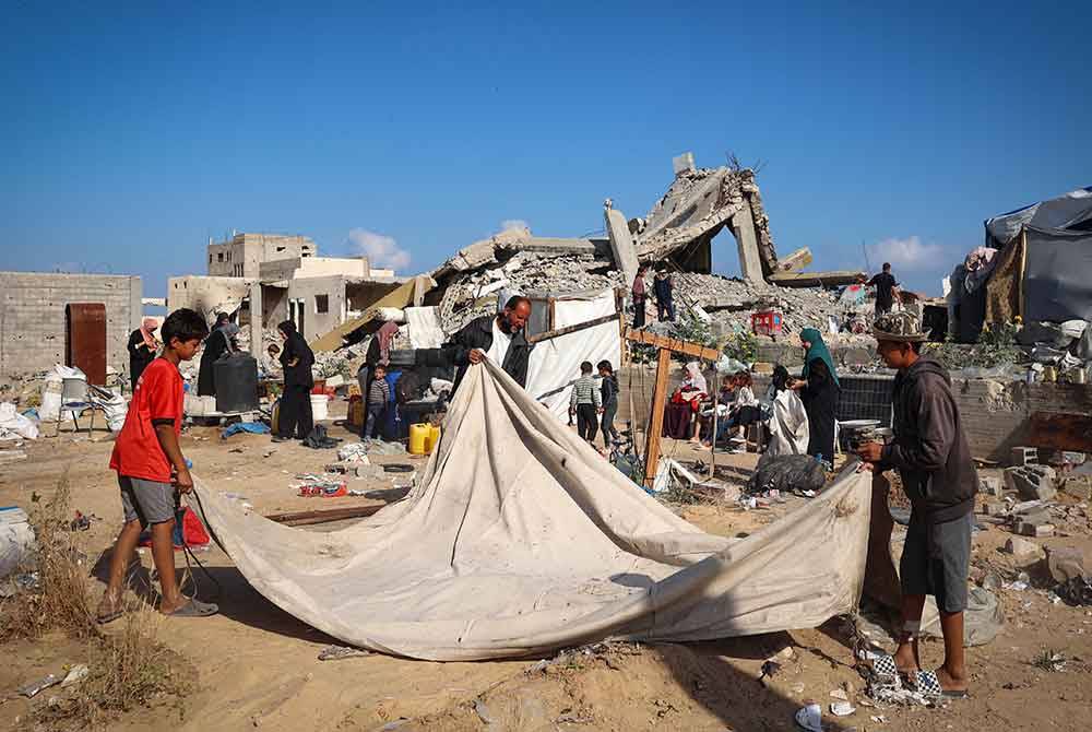 Pelarian Palestin mengemas khemah mereka sebelum berpindah keluar dari Rafah ketika Israel melancarkan serangan di bandar itu. - AFP