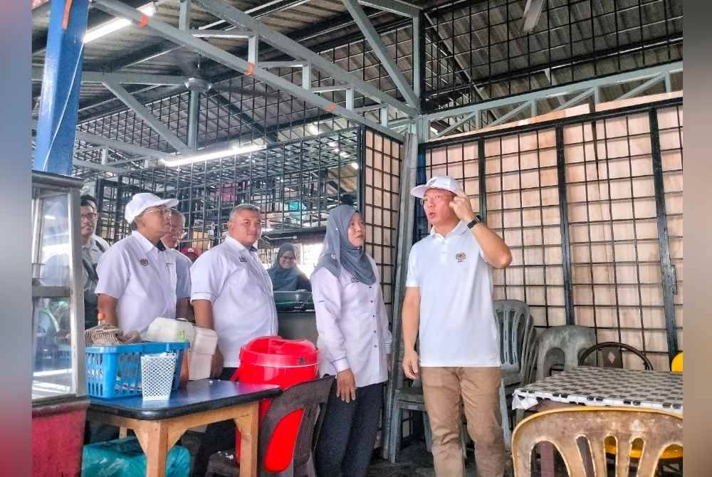 Kor Ming (kanan) ketika lawatan kerja di Medan Selera Sultan Muhammad sempena rangka lawatan program Sentuhan Kasih KPKT di Batu Berendam pada Sabtu.