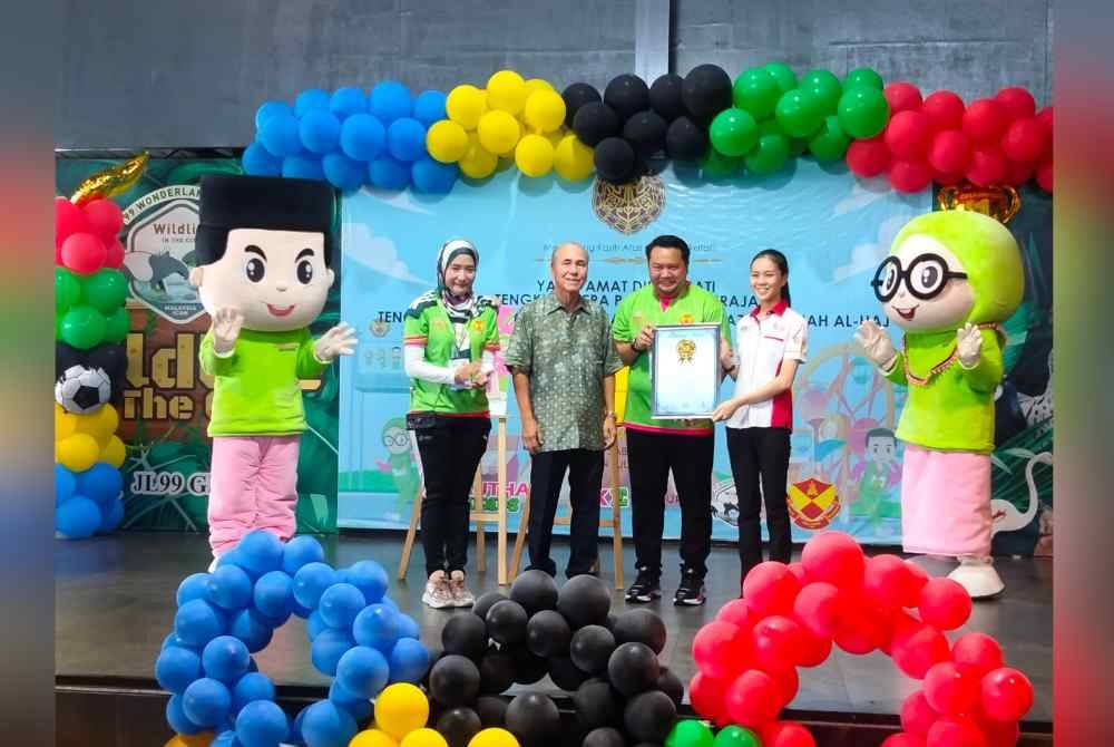 Wakil Malaysia Books Of Records, Jeska Seah (kanan) menyerahkan sijil kepada pihak pengurusan AKE sambil disaksikan Tengku Datuk Setia Putra Alhaj (dua dari kiri).