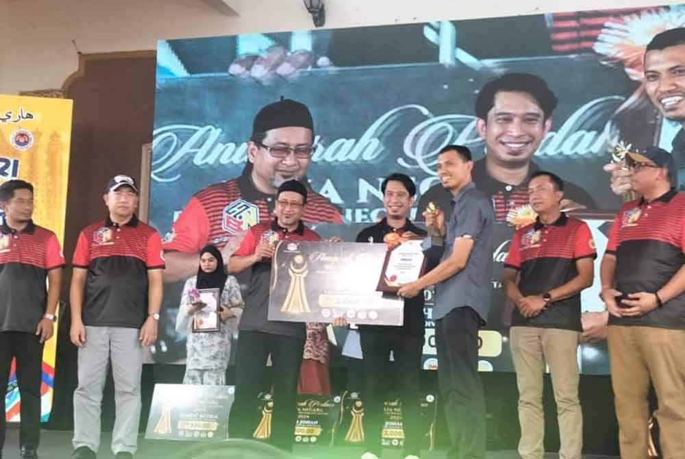 Adam Adli (tengah) menyampaikan hadiah kepada salah seorang tokoh belia Kelantan sempena Hari Belia Negara 2024 Peringkat Negeri Kelantan pada Sabtu.