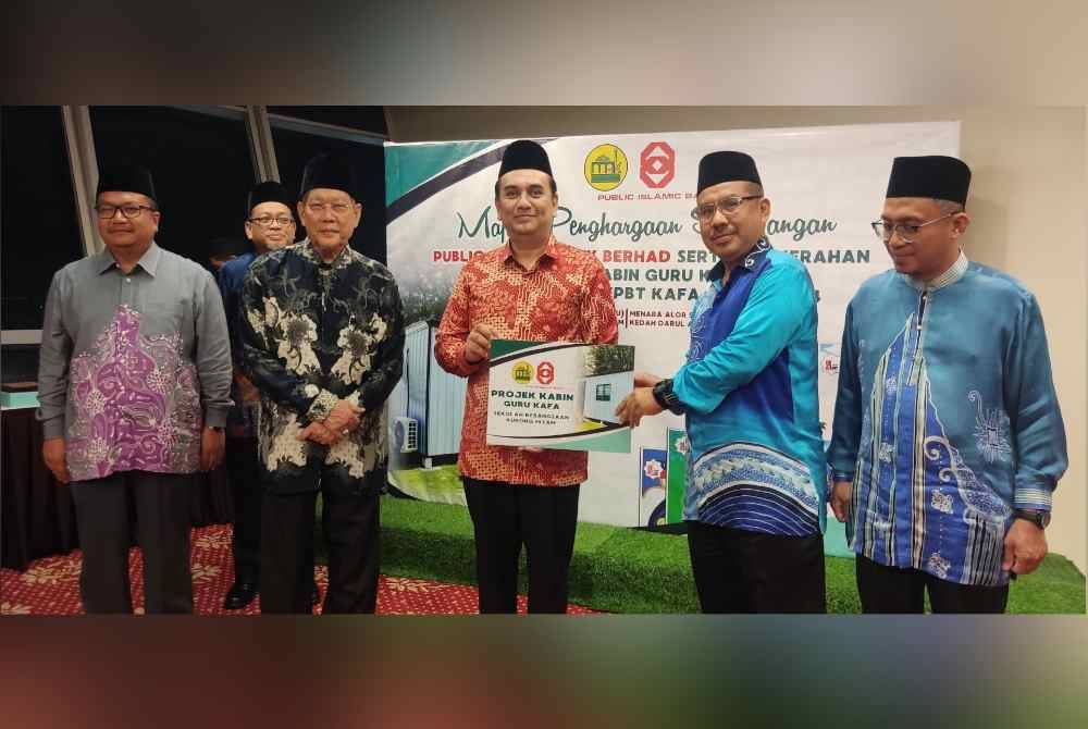 Mufti Kedah, Datuk Fadzil Awang (dua dari kiri) menyaksikan penyerahan gimik projek kabin guru Kafa daripada Ketua Pegawai Eksekutif PIBB, Syamsul Azuan Ahmad Fauzi (tiga dari kanan) pada malam Sabtu.