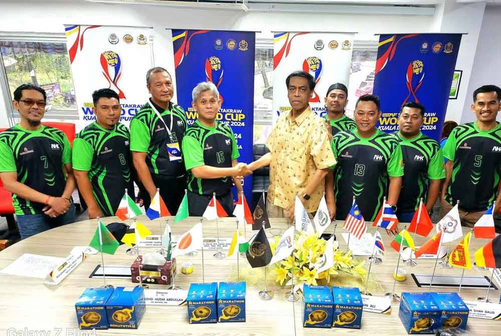 Abdul Halim (lima dari kanan) bersalaman dengan Abdul Hafiz selepas menyampaikan sumbangan penajaan kelengkapan sepak takraw kepada Tim Media sempena Piala Dunia Sepak Takraw di Stadium Titiwangsa, Kuala Lumpur pada Sabtu.