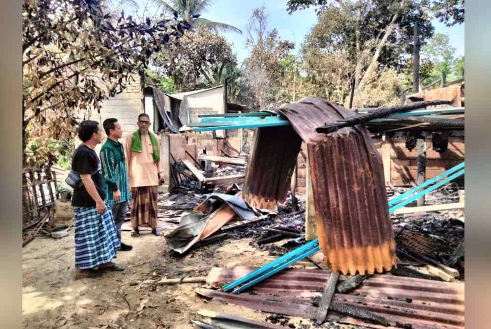 Nik Asma&#039;Bahrum (tengah) melihat kediaman Mohd Azizi yang hangus.