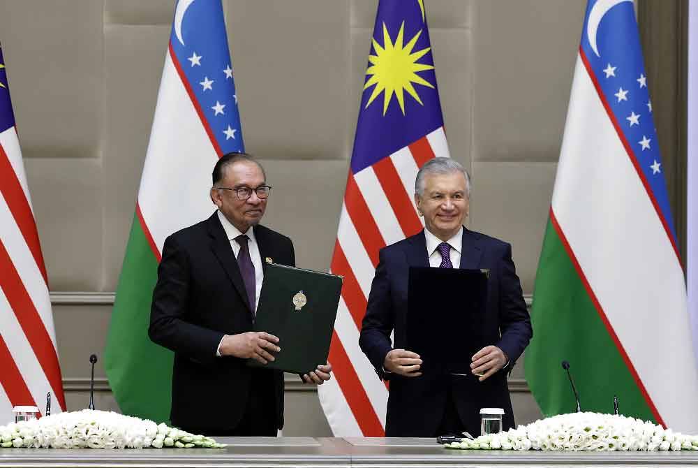 Anwar dan Presiden Uzbekistan bertukar dokumen selepas menandatangani kenyataan bersama pada pertemuan di Istana Presiden Kuksaroy. Foto Bernama