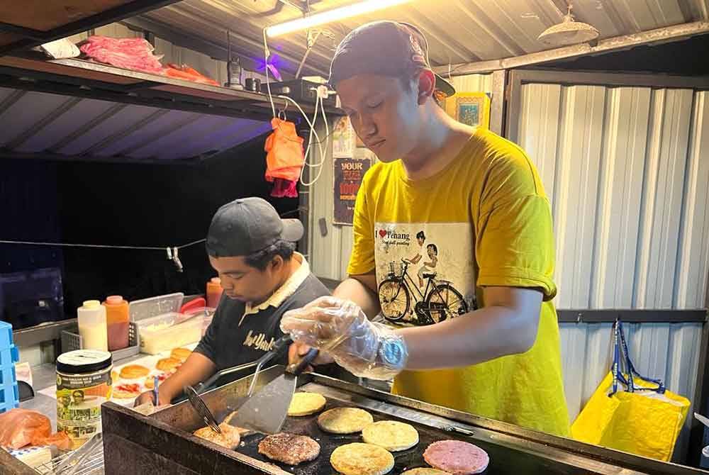 Dua pekerja Eko Burger&#039;s menyiapkan tempahan pelanggan di gerai yang beroperasi di Jalan Budiman, Kuala Terengganu.