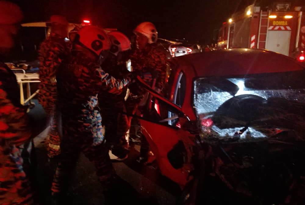 Pasukan bomba menjalankan operasi mengeluarkan mangsa yang tersepit dalam kenderaan sebelum disahkan meninggal dunia oleh pegawai kesihatan di lokasi kejadian. Foto ihsan Bomba Perak