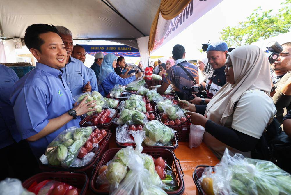 Arthur (kiri) turut mempromosikan sayuran yang dijual kepada pengunjung selepas merasmikan Karnival Agro Madani Mega di pekarangan Majlis Perbandaran Tawau pada Sabtu. Foto Bernama