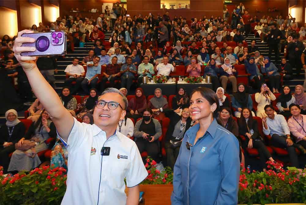 Fahmi (kiri) berswafoto pada majlis dialog bersama mahasiswa sempena Jelajah Hari Wartawan Nasional (Hawana) 2024 di Pustaka Negeri Sarawak di Petra Jaya, pada Sabtu. Foto Bernama