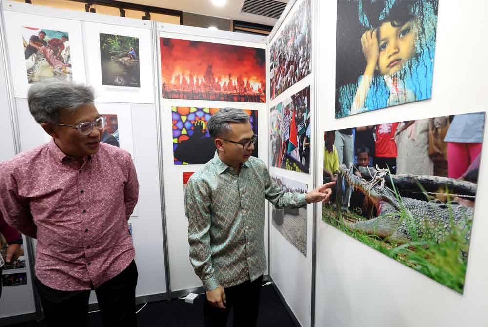 Fahmi (kanan) melihat pameran fotografi pada perasmian Pameran Hawana 2024. Foto Bernama