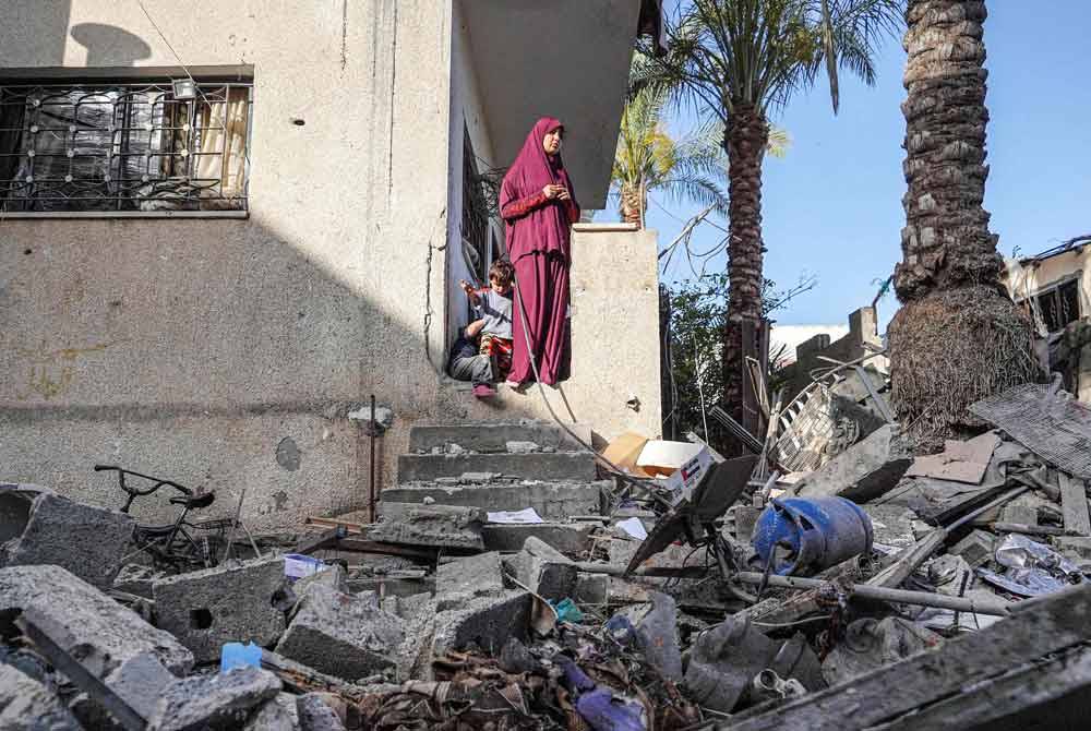 Wanita Palestin ini melihat keadaan rumahnya yang musnah dibom Israel. Foto AFP