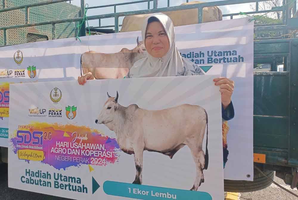 Sarimah bersama lembu yang dimenangi menerusi cabutan bertuah sempena Showcase Satu Daerah Satu Industri (SDSI) dan Hari Jelajah Usahawan, Agro dan Koperasi Negeri Perak 2024 di Stadium Indera Mulia, Ipoh.