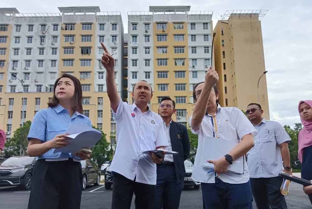 Dari kiri Cai Tung, Mohd Jafni dan Mohd Khairul melawat Blok D dan Blok E di Taman Seri Molek Perdana, Johor Bahru yang terbengkalai sejak 10 tahun lalu