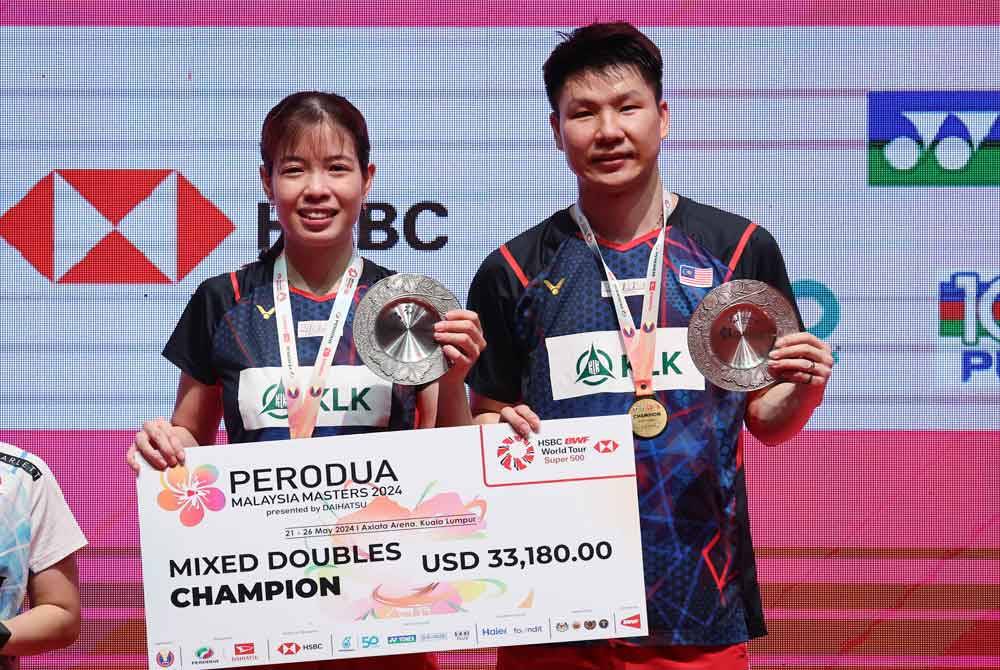 Pasukan beregu campuran negara, Goh Soon Huat (kanan) dan Lai Shevon Jemie menjulang Piala Kejohanan Badminton Masters Malaysia 2024 selepas Malaysia menang kepada Indonesia 21-18, 21-19 pada pusingan akhir perlawanan Kejohanan Badminton Masters Malaysia Axiata Arena, Bukit Jalil pada Ahad. Foto Bernama 