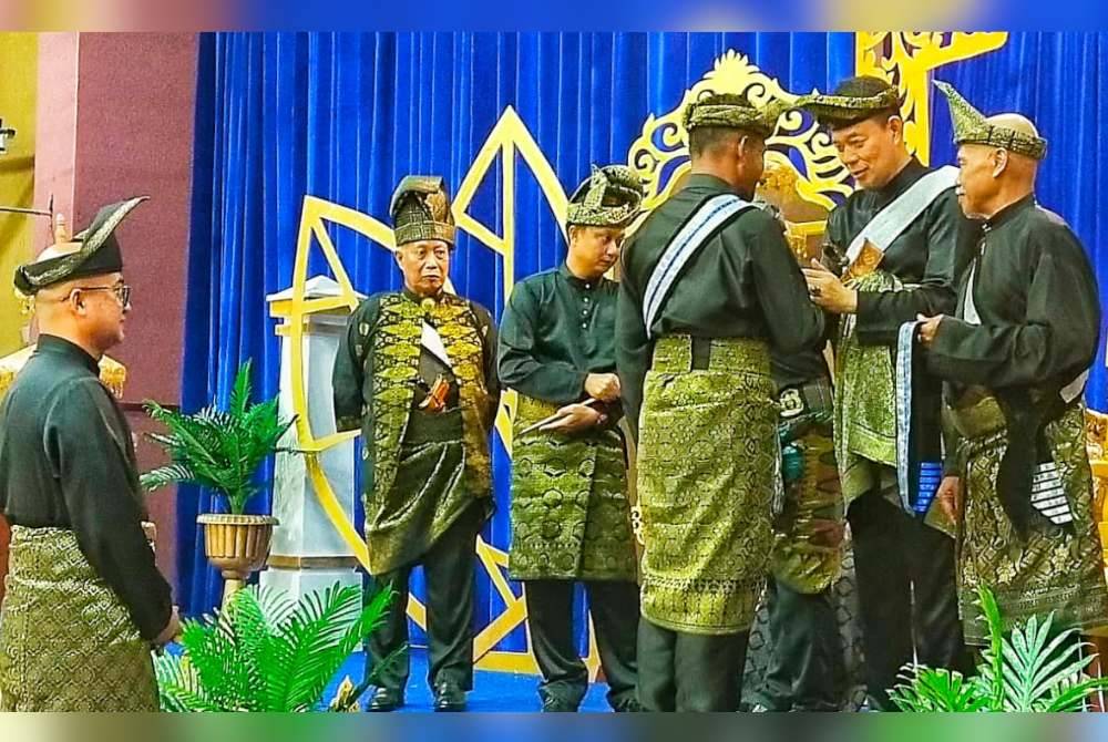 Tengku Kamarulzaman (dua dari kanan) memakaikan sandang kepada salah seorang penerima pada Program Pemakaian Sandang Penjawatan dan Kehormat PSSGM Pahang di Dewan Konvensyen Sultan Ahmad Shah pada malam Ahad.