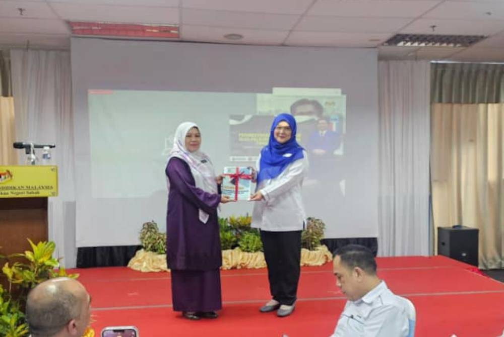 Nurani Fauziah (kiri) ketika menerima teks ucapan pengumuman keputusan peperiksaan SPM Tahun 2023 di Wisma JPNS, Kota Kinabalu.