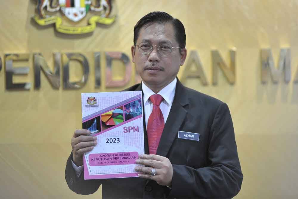 Ketua Pengarah Pendidikan, Azman Adnan menunjukkan buku laporan prestasi SPM 2023 di Kementerian Pendidikan pada Isnin.