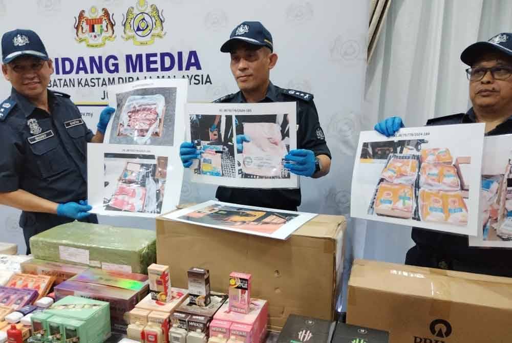 Aminul Izmeer (tengah) menunjukkan rokok elektronik dan cecair rokok elektronik bernilai RM805,200 yang cuba diseludup ketika sidang akhbar.