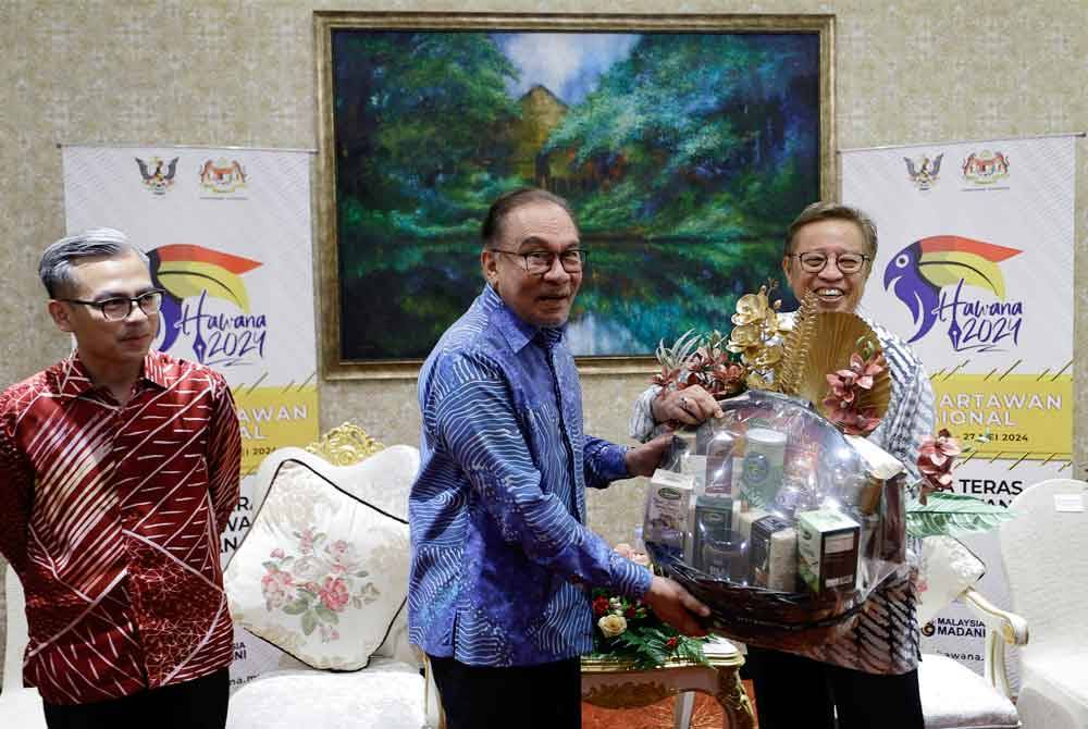 Anwar menyerahkan cenderahati kepada Abang Johari ketika menghadiri Majlis Kemuncak Hawana 2024 pada Isnin. Foto Bernama