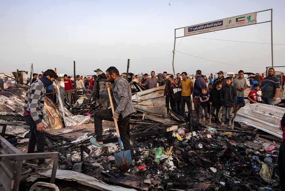 Rakyat Palestin memeriksa kerosakan selepas tentera Israel menyerang kem di kawasan yang dikhaskan untuk pelarian di Rafah, selatan Semenanjung Gaza. Foto EPA