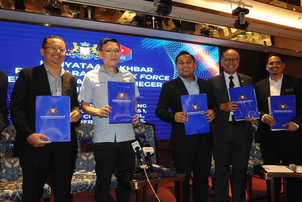 Mohamad Fazli (tiga dari kanan) dan Ting Han (dua dari kiri) menunjukkan PlanMalaysia@Johor selepas Mesyuarat Penyelarasan Task Force Projek Berimpak Tinggi Negeri Johor di Iskandar Puteri, pada Selasa.