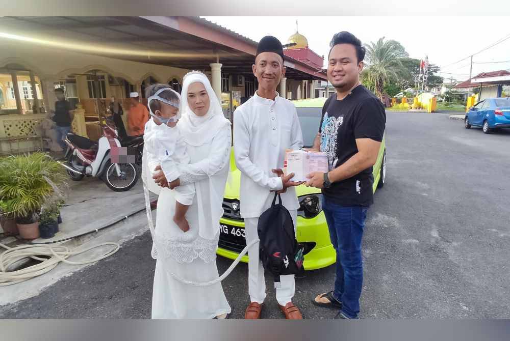 Firdaus (kanan) menyerahkan geran dan cukai jalan kereta Proton Persona selepas pasangan itu selamat dinikahkan Masjid Al Maarufi Seberang Kota, Kuala Kedah pada petang Selasa.