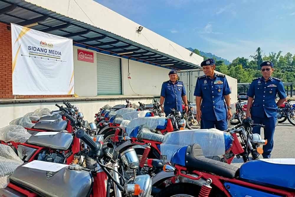 Abdul Ghafar (tengah) memeriksa 39 motosikal yang disita dalam serbuan di sebuah gudang tayar di Nibong Tebal, Pulau Pinang, 13 Mei lalu.